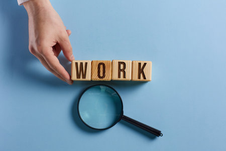 The word work is inscribed in wooden cubes. blue background.の写真素材