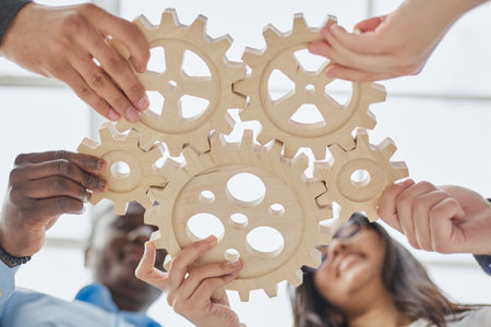 Business people holding wooden gears in the office, bottom viewの写真素材