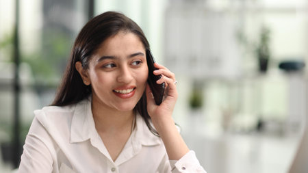 Portrait of young business woman with glasses ofand talking on mobile phoneの写真素材