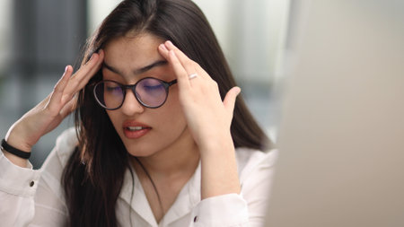 Beautiful portrait of a young woman and female student, while working on her computer or laptop at...