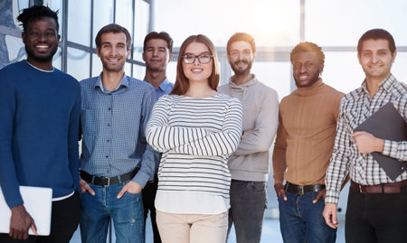 Confident in your team. Attractive young business people smiling while standing in a row with other peopleの写真素材