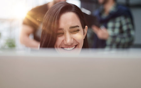 Woman concentrating as she works on a laptopの写真素材