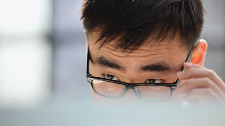 man in shirt and glasses using laptop at work, investor pondering complex decision.の写真素材