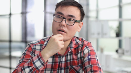 a young investor in casual clothes sits at a table and thinks about profitの写真素材