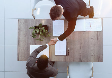 Two successful smiling businessmen are working on a laptop. view from aboveの写真素材
