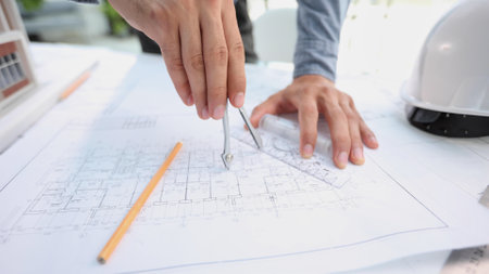 designer drawing graphic design of building project, improvement at table with papersの写真素材