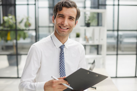 Confident businessman with black folder in the officeの写真素材
