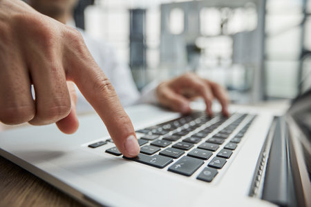 Close-up of a business persons hands on a laptop.