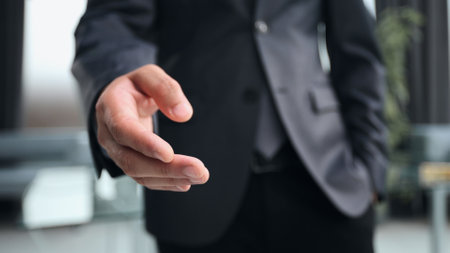 Elegant business man offering a handshake in the officeの写真素材