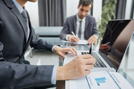 Closeup view of businessman working at sunny office on modern laptopの写真素材