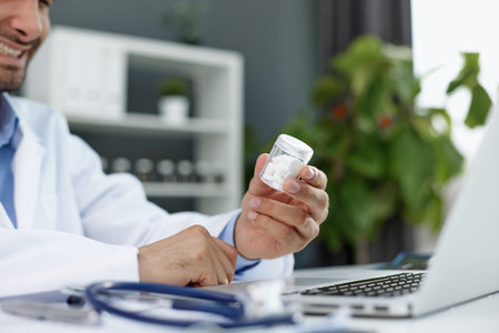 doctors hand holding a bottle of pills close-up