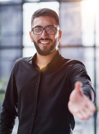 Businessman ready to shake hand in officeの写真素材