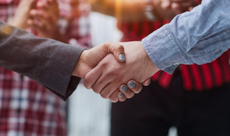 close-up of a handshake of business partners against the background of colleaguesの写真素材