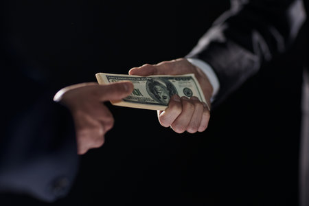 Money transfer between colleagues on a black backgroundの写真素材