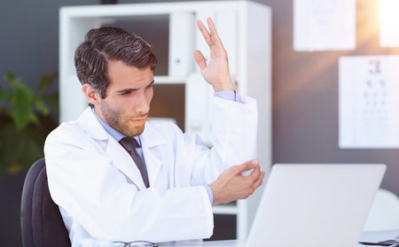 Doctor speaks with patient using laptop onlineの写真素材