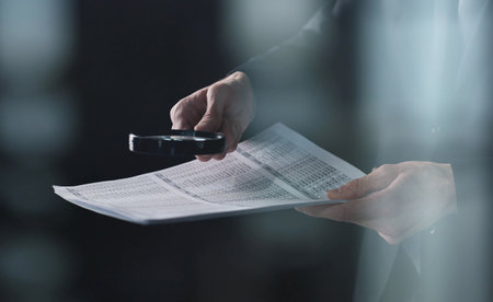 Businessman looking through a magnifying glass to contractの写真素材