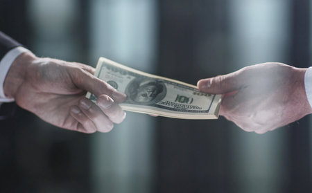 Money transfer between colleagues on a black backgroundの写真素材