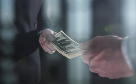 Money transfer between colleagues on a black backgroundの写真素材