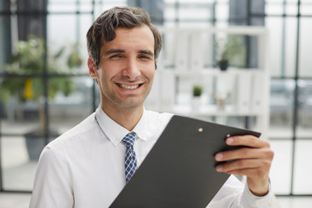 Confident businessman with black folder in the officeの写真素材