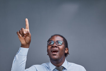 young african american man surprised showing fingers up on gray backgroundの写真素材