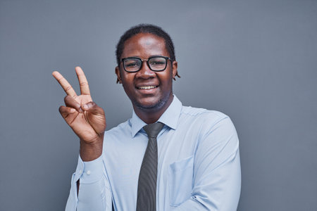 young african american man surprised showing victory signの写真素材