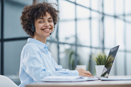girl in a modern office working in a call center smilingの写真素材