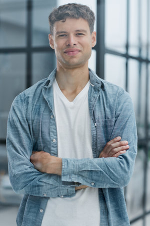 Portrait of smiling mid adult businessman standing at corporate officeの写真素材