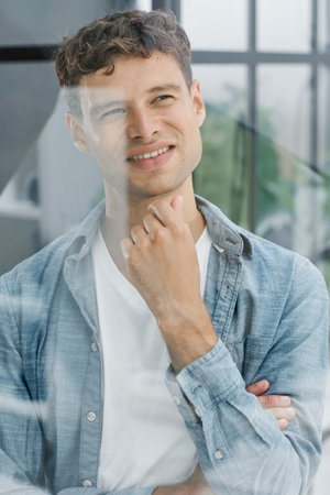 Portrait of smiling mid adult businessman standing at corporate officeの写真素材