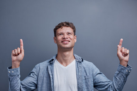 a man on a gray background points to the top