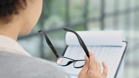 woman in the office looking through paper documentsの写真素材