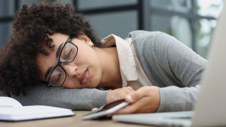 woman in the office sleeping at the workplace at the computerの写真素材