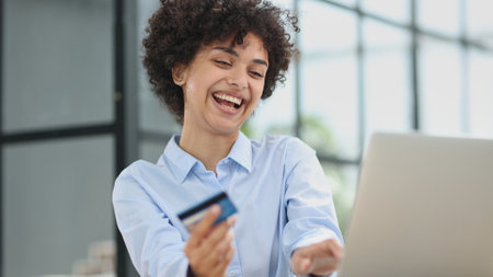 a girl in a modern office pays for purchases on the Internet using a credit card