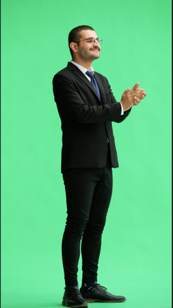 young man in full growth. isolated on green background applaudsの写真素材