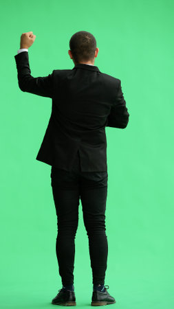 young man in full growth. isolated on green background applaudsの写真素材