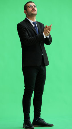 young man in full growth. isolated on green background rejoicesの写真素材