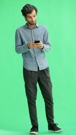 young man in full growth. isolated on green background taking selfieの写真素材
