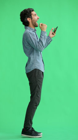 young man in full growth. isolated on green background taking selfieの写真素材
