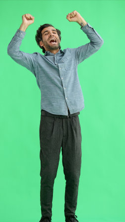 man in full growth. isolated on green background jumping rejoicesの写真素材