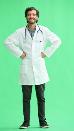male doctor in a white coat on a green background smiling in full length