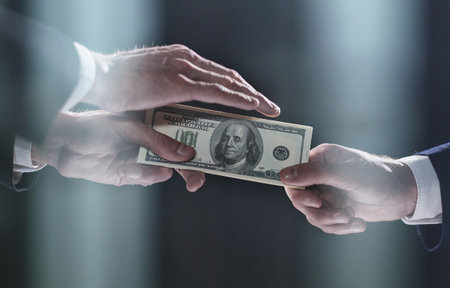 transferring money from hand to hand on a black backgroundの写真素材