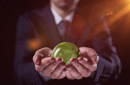 man holding a small green glass ball, generative aiの写真素材