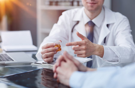 doctor pointing his finger at the pills at the tableの写真素材