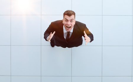 Celebrating success. Low angle view of excited young businessman keeping armsの写真素材