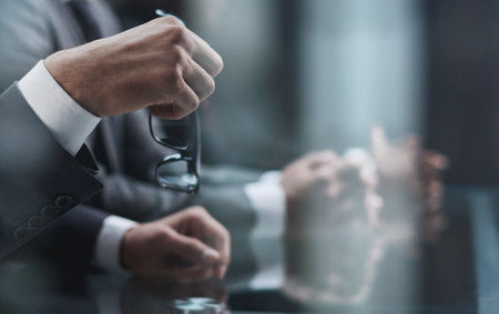 Close up of male hands holding a pair of glassesの写真素材