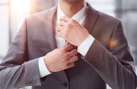 business man in a white shirt, a man straightens his tieの写真素材