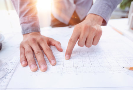 designer drawing graphic design of building project, improvement at table with papersの写真素材