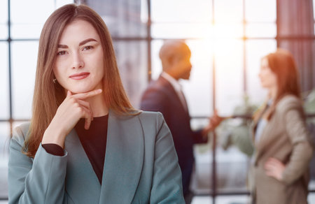 Portrait of a confident young businesswoman standing with her arms crossed in an officeの写真素材