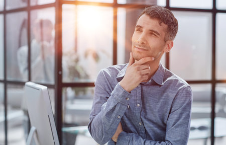 Serious thoughtful millennial business man looking awayの写真素材