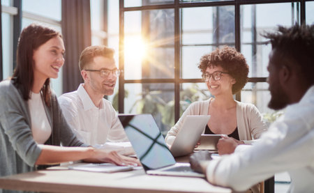 Employees working at computer together, discussing contentの写真素材