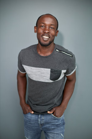 Portrait of a black man with his arms crossed on a gray background.の写真素材